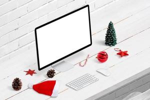 mockup del display del computer sulla scrivania circondato da decorazioni natalizie. vista isometrica foto