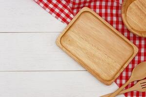 vuoto rettangolo di legno piatto con cucchiaio e forchetta su bianca di legno tavolo. superiore Visualizza Immagine. foto