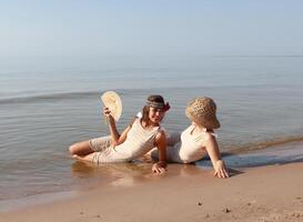 Due giovane donne nel retrò costumi da bagno di il mare foto