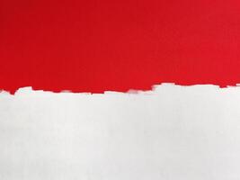 grunge bianca dipingere su un' metà rosso cemento parete. foto