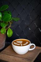 latte macchiato arte caffè tazza su di legno piatto nel buio sfondo. foto