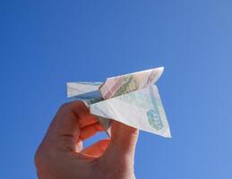denominazioni di russo i soldi, piegato nel il aereo contro il blu cielo nel mano foto