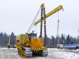 un' bulldozer con un' sollevamento su il costruzione di un' tubatura nel il taiga. foto