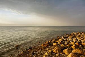 Visualizza di morto mare costa a tramonto tempo nel Giordania. sale cristalli a tramonto. morto mare paesaggio con minerale strutture. foto