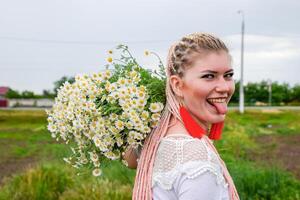 giovane ragazza con un' mazzo di margherite nel campo. margherite su un' papavero campo. foto