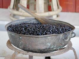 caffè tostatura, struttura di caffè fagioli, caffè fagioli fette di verde le foglie. bellissimo luce, vigore di fagioli, tra caffè cespugli, arrostito fagioli su vecchio di legno tavolo foto