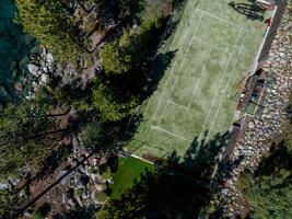 un' uccelli occhio Visualizza di un' tennis Tribunale circondato byforest. foto