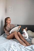 un' giovane bellissimo ragazza disegna nel sua gratuito tempo a casa, Il prossimo per sua è un' Jack russell terrier cane foto