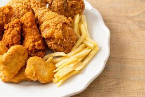 pollo fritto con patatine fritte e pepite sul piatto foto