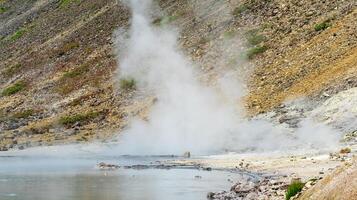 caldo idrotermale acqua presa su il riva di il lago nel il caldera di il golovnin vulcano su il isola di kunashir foto