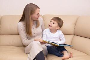 donna lettura libro per bambino in casa foto