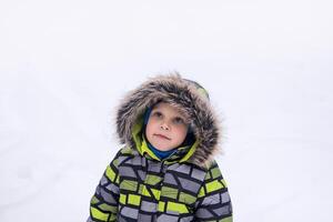 poco ragazzo a piedi nel inverno nevoso parco foto