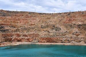 vecchio calcare cava con un' blu lago a il parte inferiore foto