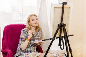 sorridente femmina artista guardare a il telaio foto