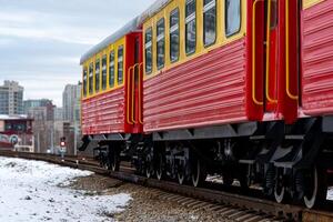 passeggeri treno su un' stretto valutare ferrovia contro il sfondo di il città foto