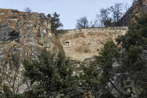 Visualizza di il rovine di un antico antico fortezza parete fra il rocce foto