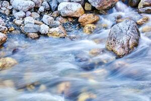 naturale sfocato sfondo - veloce flusso di acqua nel un' montagna fiume foto