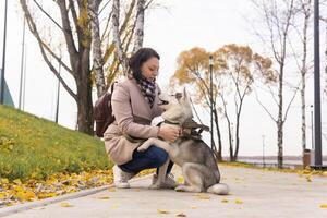 giovane donna comunica con sua rauco cane nel autunno parco foto