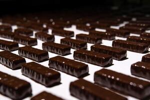 cioccolato caramelle su il trasportatore di un' confetteria fabbrica avvicinamento foto