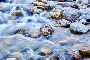 acqua flusso nel un' roccioso montagna ruscello sfocato nel movimento foto