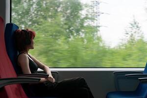 cirl nel un' in movimento suburbano treno sembra su il finestra foto