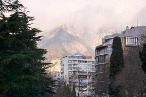 mattina paesaggio urbano nel il montagne - Residenziale edifici su il sfondo di nebbioso montagne foto