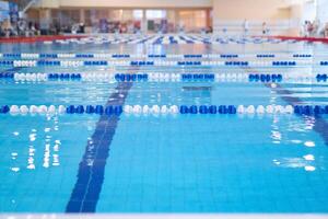 frammento di il concorrenza piscina con blu acqua e segnato nuoto corsie foto