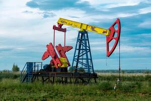 pumpjack operativo a un olio bene nel campo all'aperto foto