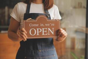 avvio di successo della piccola impresa titolare sme bellezza ragazza stand con tablet smartphone nel ristorante caffetteria. ritratto di donna asiatica abbronzata barista barista proprietario. concetto di business venditore imprenditore PMI foto