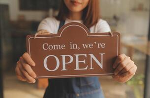 avvio di successo della piccola impresa titolare sme bellezza ragazza stand con tablet smartphone nel ristorante caffetteria. ritratto di donna asiatica abbronzata barista barista proprietario. concetto di business venditore imprenditore PMI foto