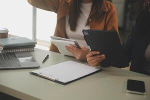 asiatico donna d'affari Lavorando su il computer portatile computer Guarda per lavoro in linea, libero professionista guardare e digitando su taccuino su tavolo, stile di vita di donna studiando in linea foto