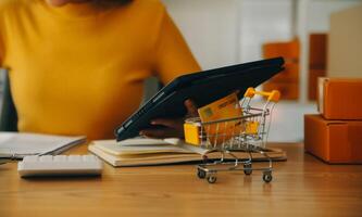 giovane donna piccolo imprenditore shopping online a casa. prendere nota degli ordini dei clienti con telefoni cellulari. piccolo imprenditore o concetto di stile di vita freelance. foto