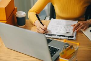 giovane donna piccolo imprenditore shopping online a casa. prendere nota degli ordini dei clienti con telefoni cellulari. piccolo imprenditore o concetto di stile di vita freelance. foto