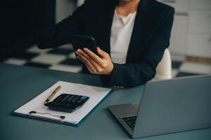 ispanico donna d'affari nel formale abbigliamento nel sua ufficio contento e allegro mentre utilizzando smartphone e Lavorando. giovane donna d'affari utilizzando applicazioni su cellula telefoni, lettura notizia, veloce connessione foto