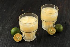 es kelapa jeruk o giovane Noce di cocco con spremuto arancia, indonesiano tropicale rinfresco bevanda foto