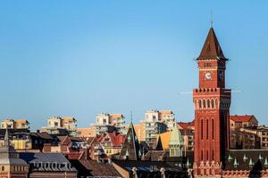 maestoso orologio Torre prospiciente il vivace paesaggio urbano foto