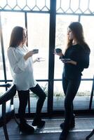 Due giovane donne assunzione autoscatto con inteligente Telefono foto