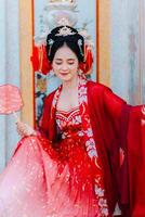 donna vestito Cina nuovo anno. ritratto di un' donna. persona nel tradizionale costume. donna nel tradizionale costume. bellissimo giovane donna nel un' luminosa rosso vestito e un' corona di Cinese Regina in posa. foto