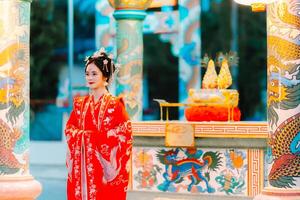 donna vestito Cina nuovo anno. ritratto di un' donna. persona nel tradizionale costume. donna nel tradizionale costume. bellissimo giovane donna nel un' luminosa rosso vestito e un' corona di Cinese Regina in posa. foto