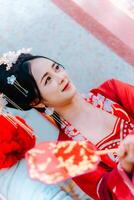 donna vestito Cina nuovo anno. ritratto di un' donna. persona nel tradizionale costume. donna nel tradizionale costume. bellissimo giovane donna nel un' luminosa rosso vestito e un' corona di Cinese Regina in posa. foto