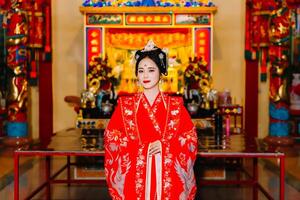 donna vestito Cina nuovo anno. ritratto di un' donna. persona nel tradizionale costume. donna nel tradizionale costume. bellissimo giovane donna nel un' luminosa rosso vestito e un' corona di Cinese Regina in posa. foto