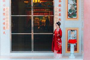 donna vestito Cina nuovo anno. ritratto di un' donna. persona nel tradizionale costume. donna nel tradizionale costume. bellissimo giovane donna nel un' luminosa rosso vestito e un' corona di Cinese Regina in posa. foto