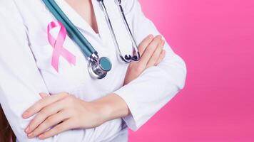 femmina medico con rosa nastro su rosa sfondo. il concetto di cancro pazienti sostegno. foto