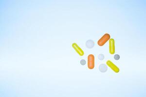 colorato pillole, capsule, vitamine volante su di un' fiala su un' blu sfondo, vita concetto, avvicinamento, copia spazio foto
