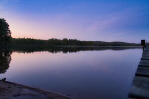 tramonto su un' lago nel Svezia. blu ora su calma acqua. natura foto a partire dal Scandinavia