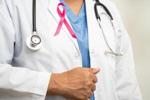 Seno cancro, asiatico medico donna con rosa nastro, simbolo di mondo Seno cancro giorno. foto