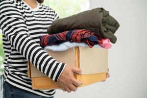 scatola per le donazioni con abiti usati a casa per sostenere l'aiuto ai poveri nel mondo. foto