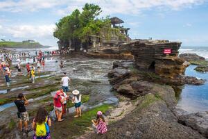 Bali, Indonesia - 16 luglio 2018 - turisti a partire dal oltremare visitare tanah lotto tempio uno di il maggior parte turista attrazione posto nel bali isola di Indonesia. foto