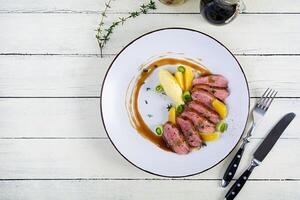 arrosto anatra filetto con schiacciato Patata e arancia salsa su di legno sfondo foto