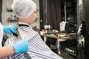 giovane ragazzo preparazione per taglio di capelli nel salone foto